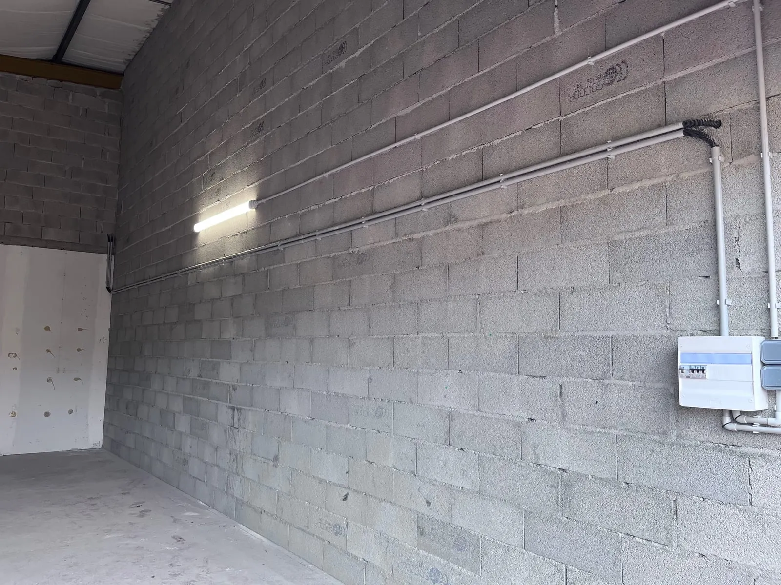 Le mur latéral du local A1, avec sa réglette d’éclairage
