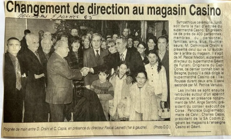 Coupure de presse de janvier 2005 titrée « Changement de direction au magasin Casino », avec une photo de Dominique Orsini serrant la main de Charles Capia devant les invités, dans le hall d'entrée du supermarché