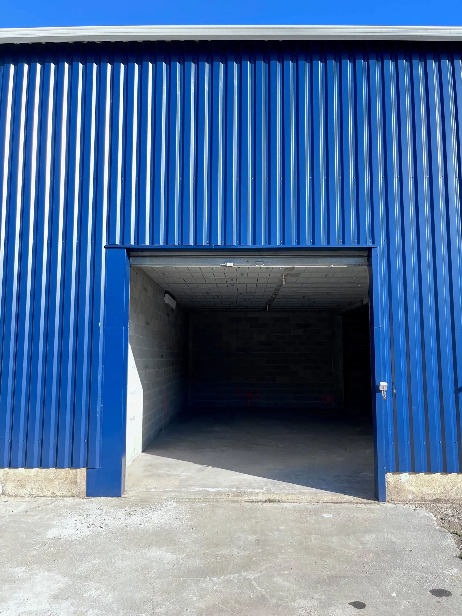 La façade bleue de l’entrepôt et la grande porte d’accès du local B2