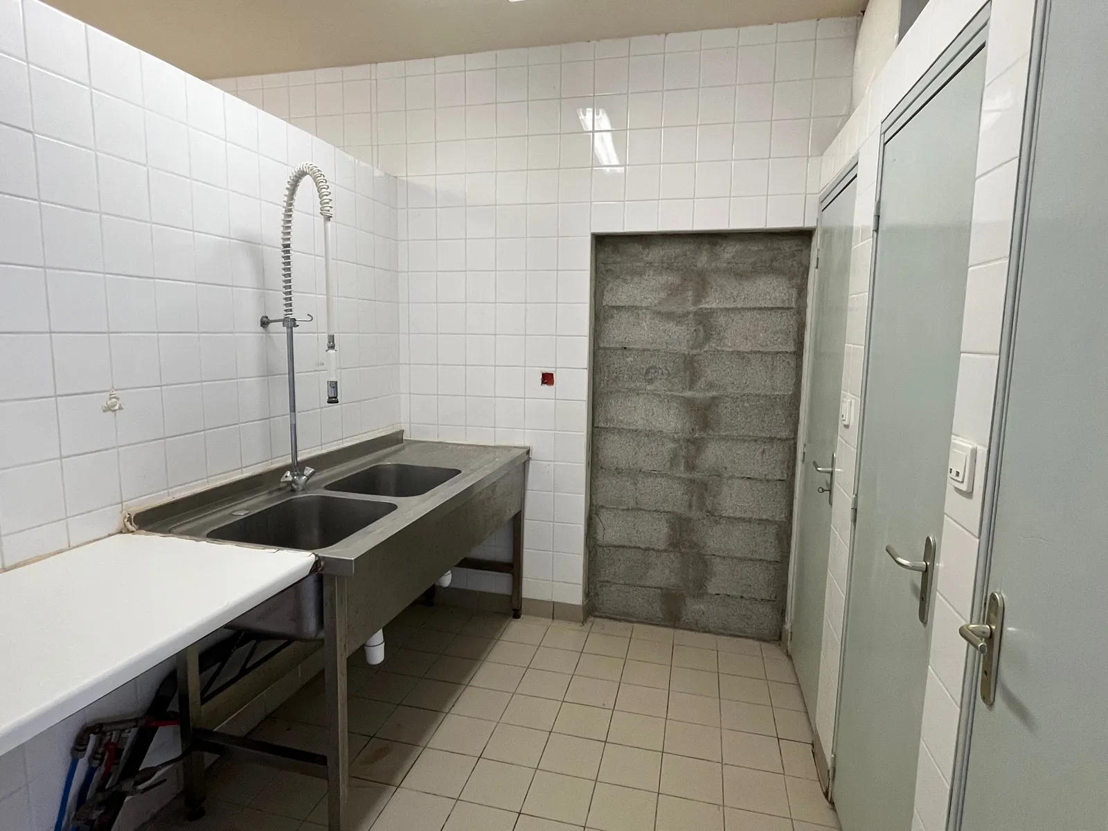 L’évier à deux bacs en inox du local C1, avec sa douchette
