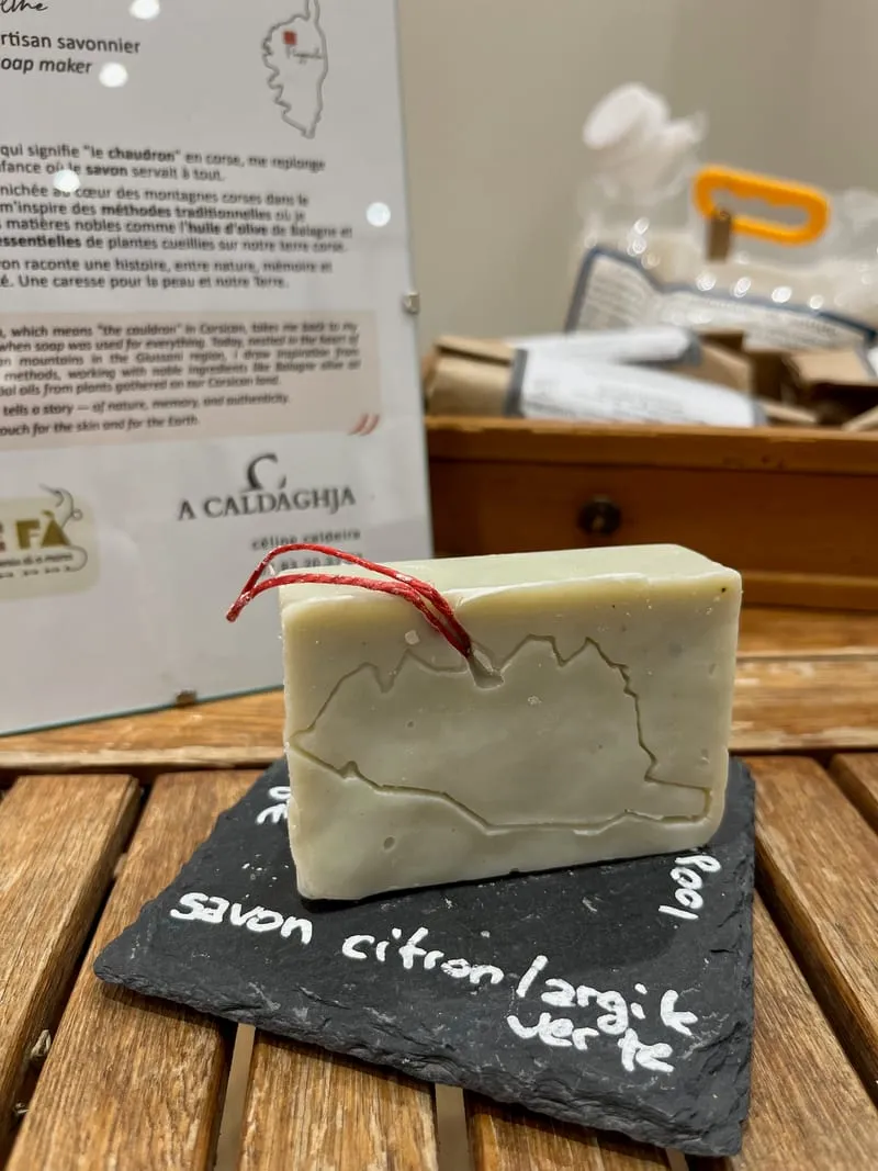 Un savon artisanal gravé de la carte de la Corse, posé sur une ardoise, sur le stand A Caldaghja