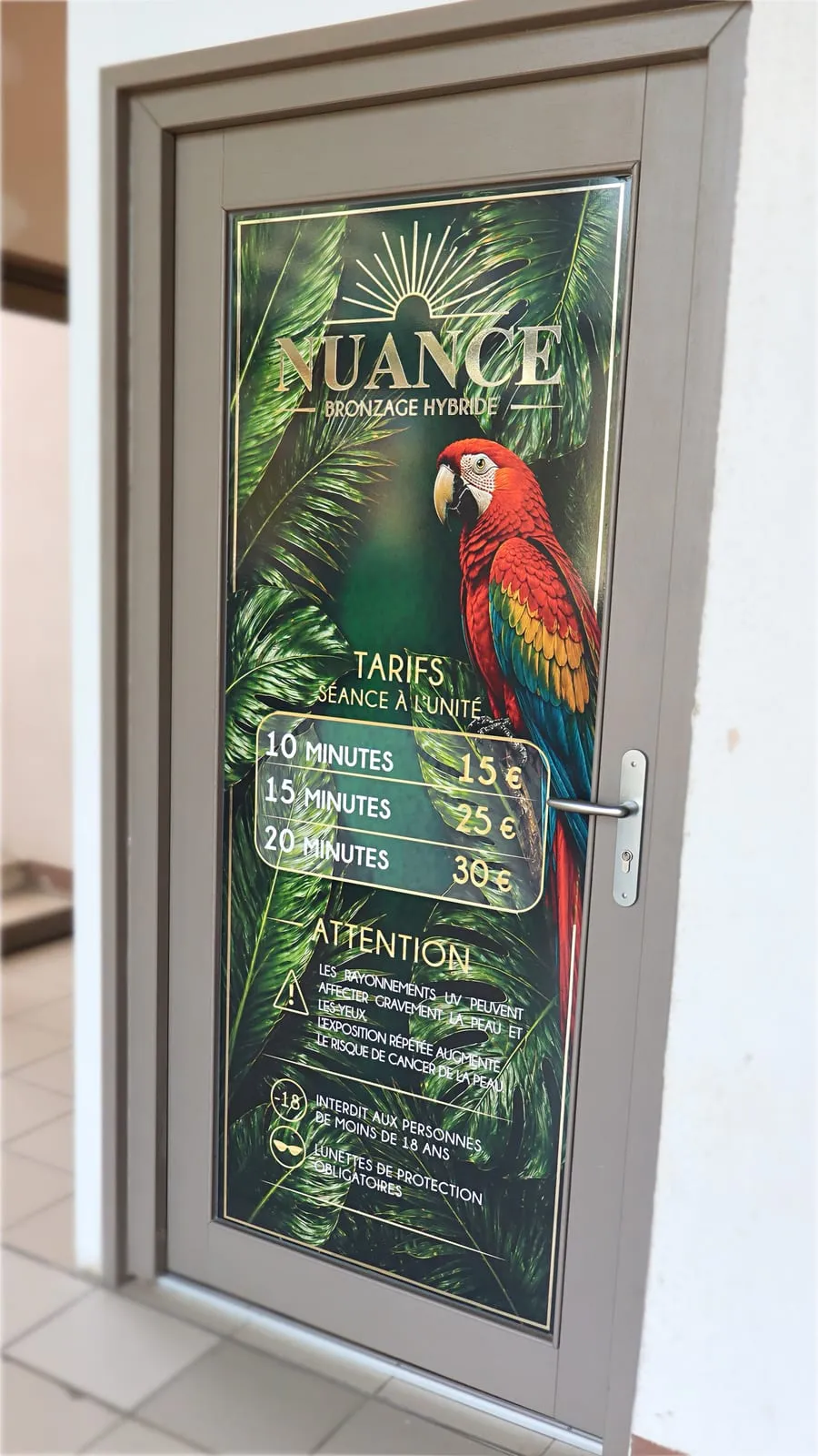 La porte de la cabine de bronzage hybride Nuance, avec ses tarifs à la séance et ses consignes de sécurité