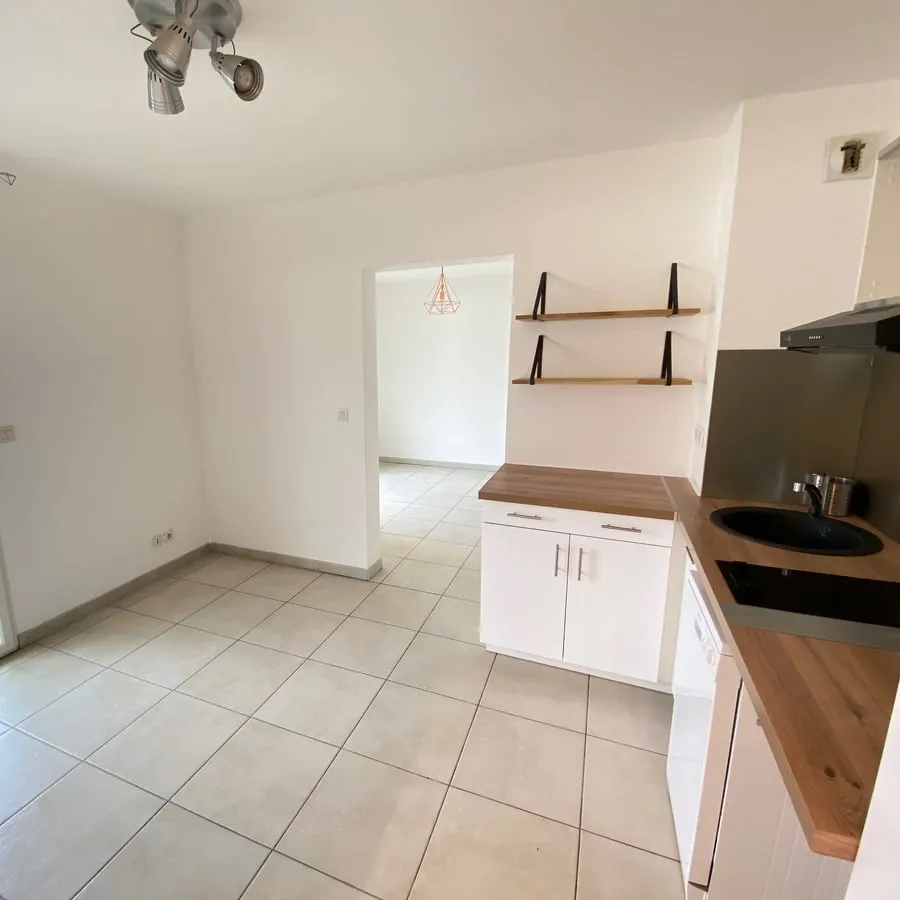 La cuisine ouverte d’un appartement, avec son plan de travail en bois