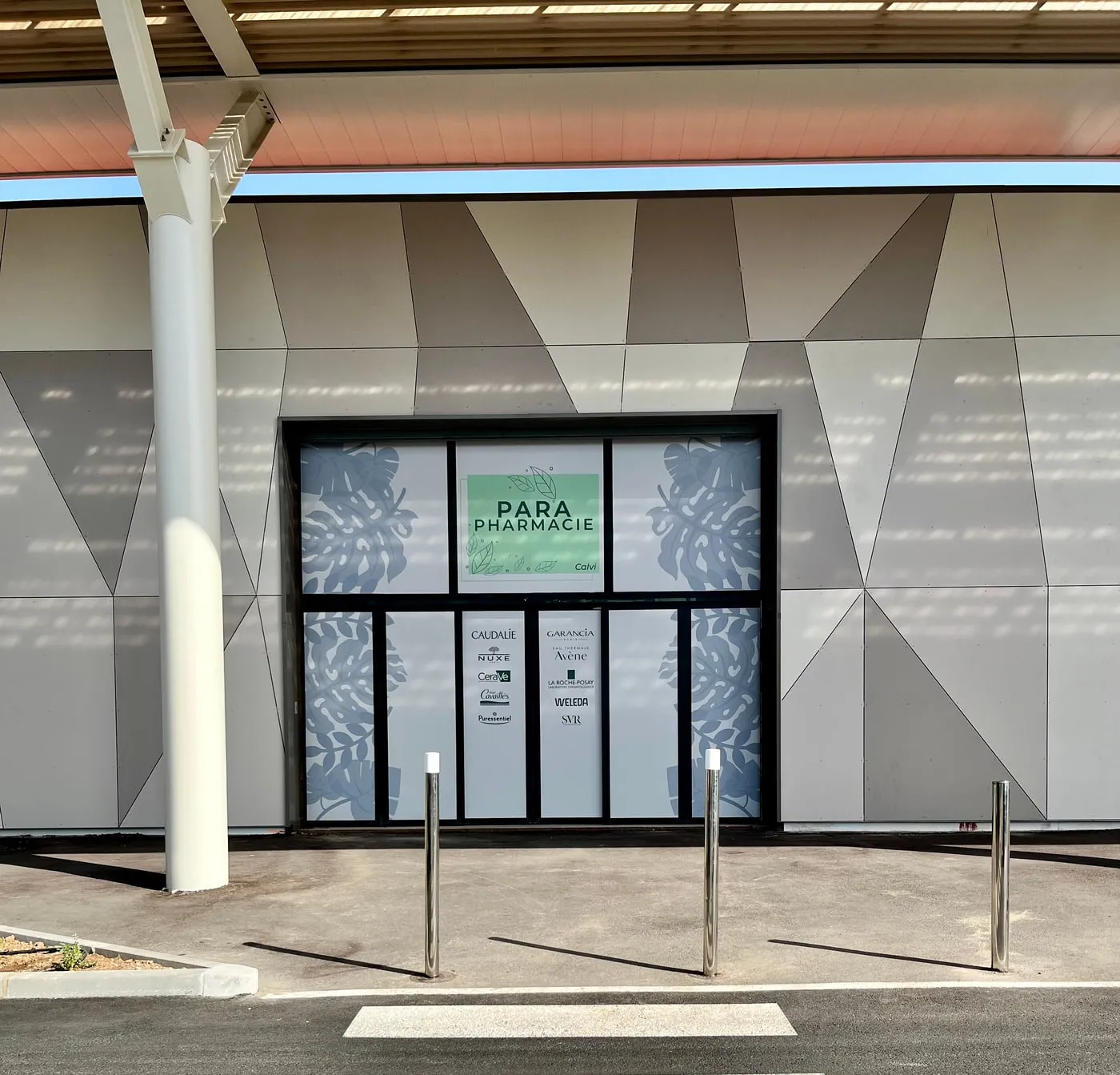 Le parvis du centre commercial MAEVA : l'espace pavé abrité par l'auvent, devant la vitrine de la parapharmacie, où s'installent les stands.