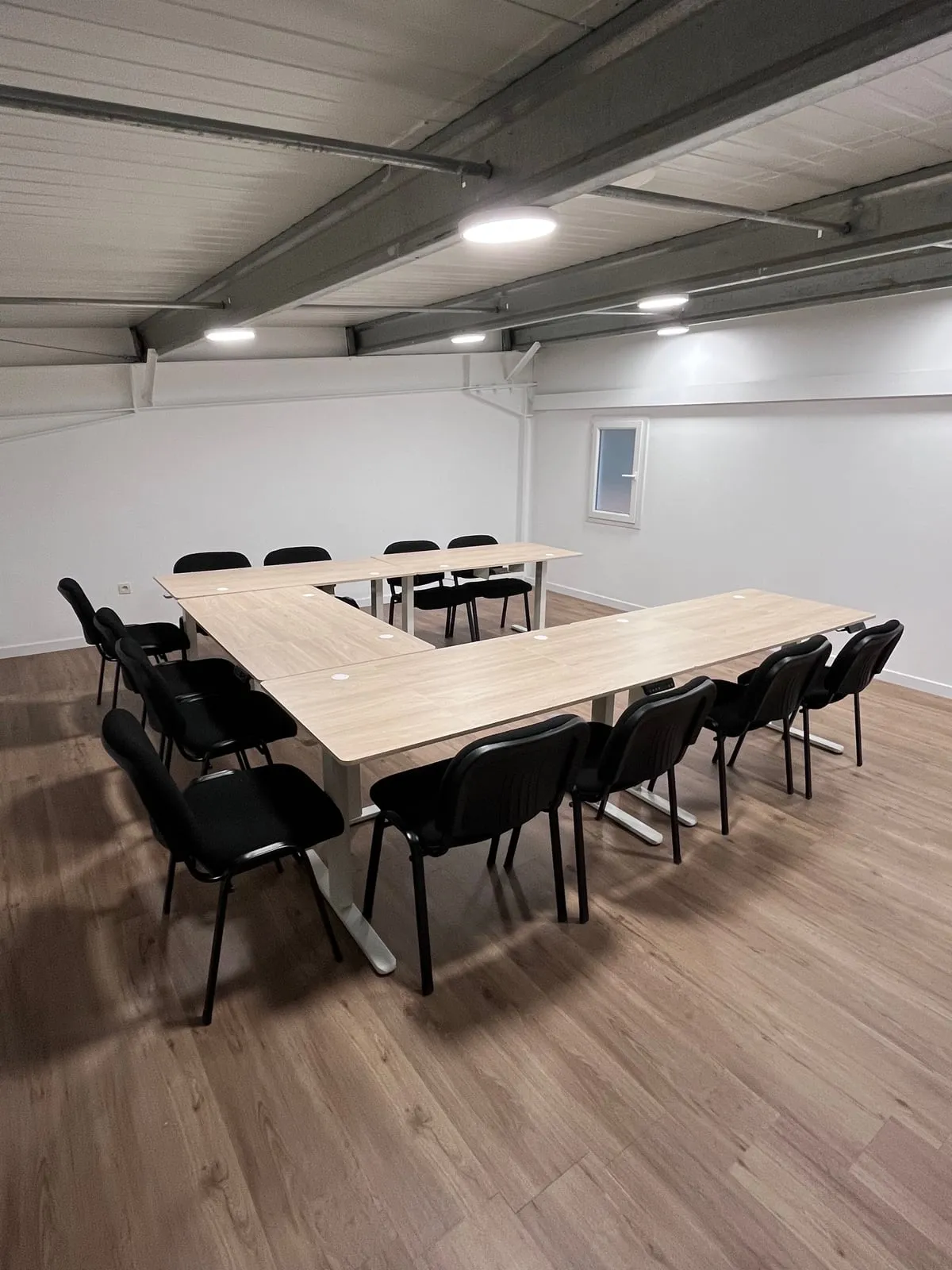 La salle de réunion et ses tables disposées en U, avec une douzaine de chaises