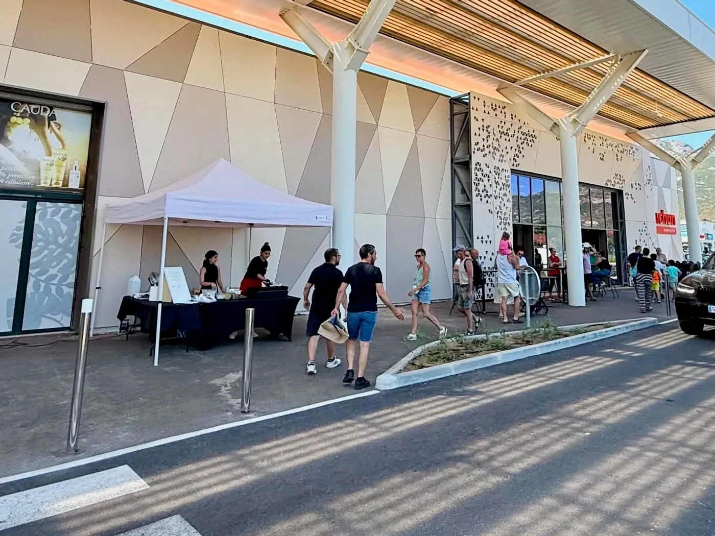 Un stand sous barnum installé sur le parvis, devant l'entrée du centre commercial